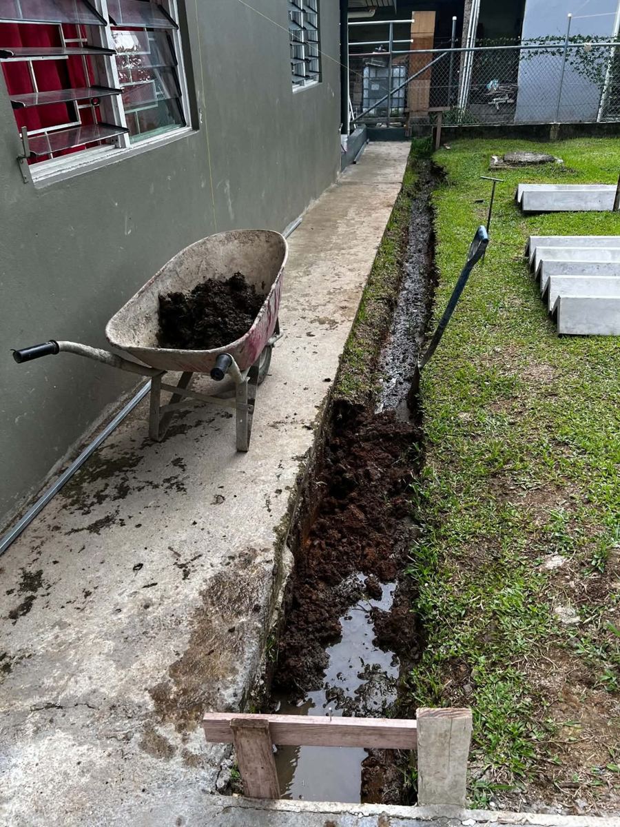 Drainage — before: waterlogged trench, precast V-drain sections ready
